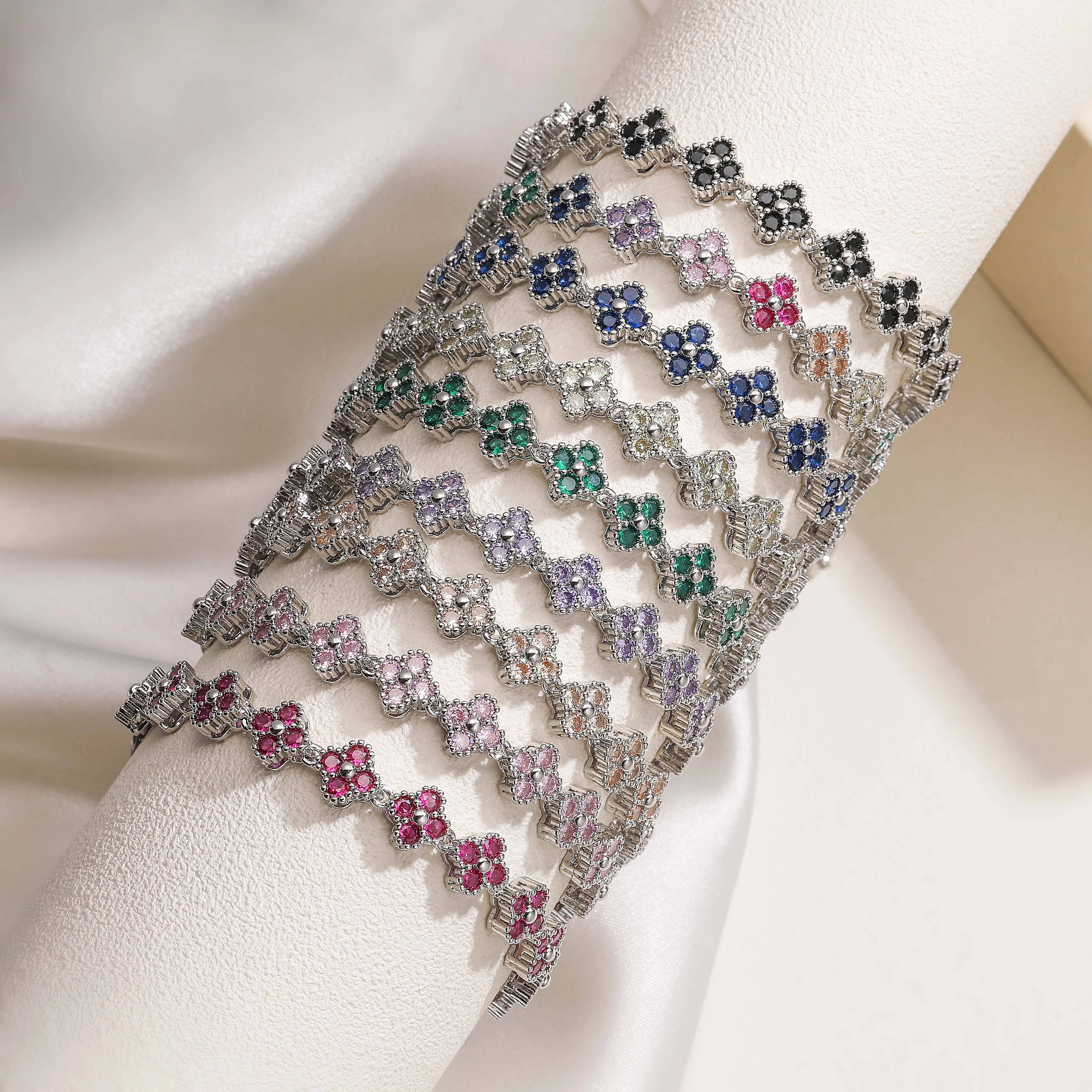 Bracelets Ambre & Lune superposés au poignet, finition argentée, fleurs en strass CZ multicolores